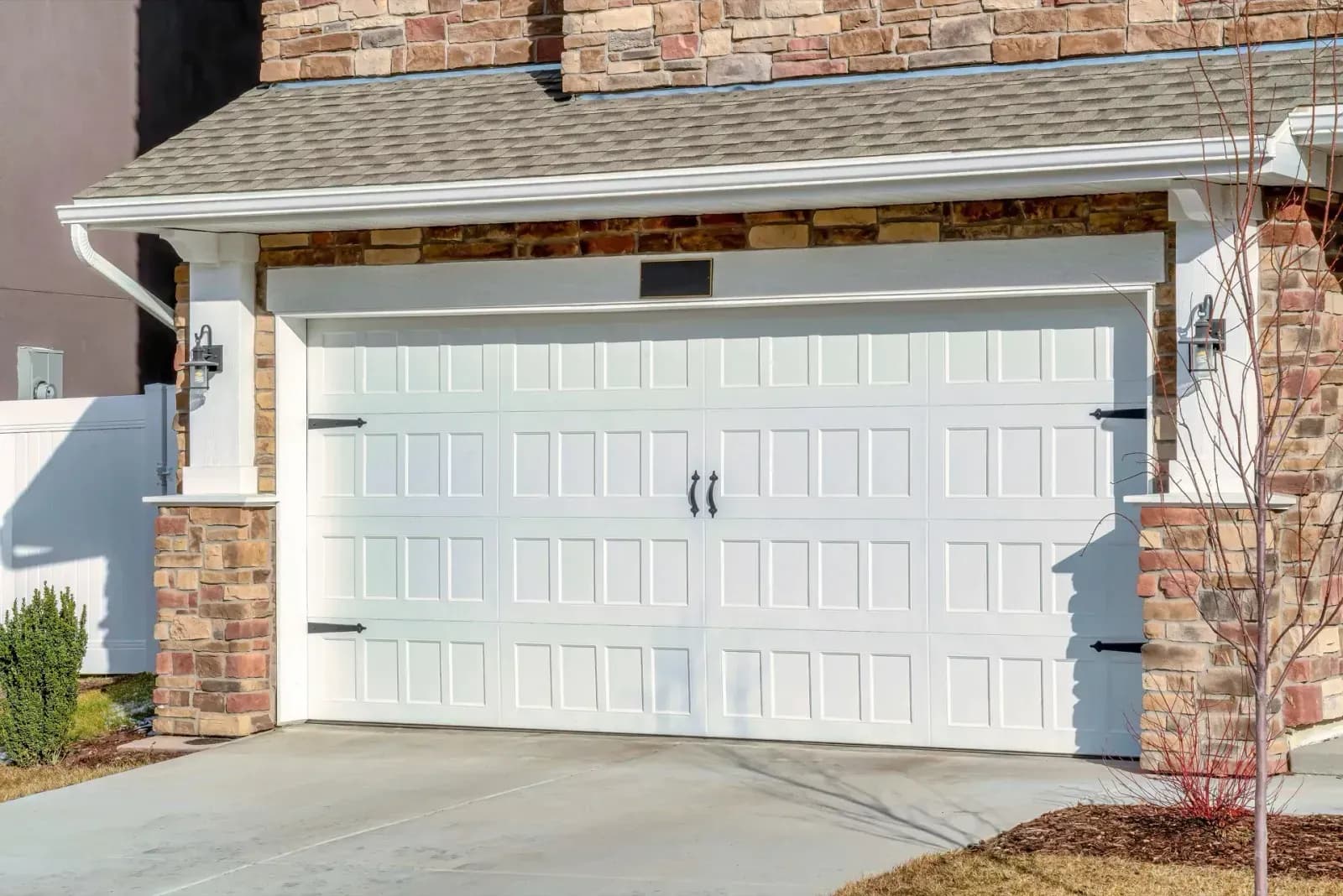 6668eb5e15c42ec43c9a488a_white-garage-door-with-stone-exterior-p-1600.webp